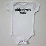 A white onepiece for infants, with "Objectively Cute" in black block letters.